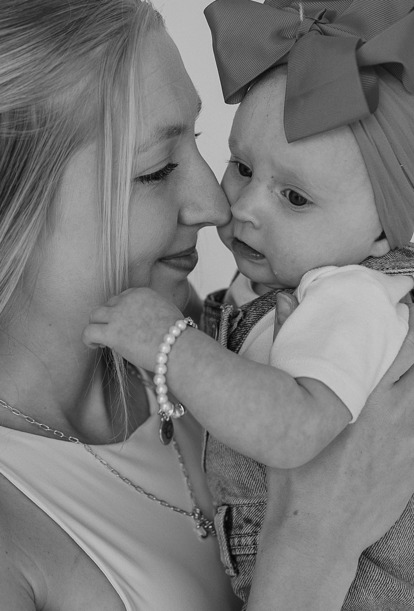 Intimate black and white portraits showing tender moments and pearl accessories.