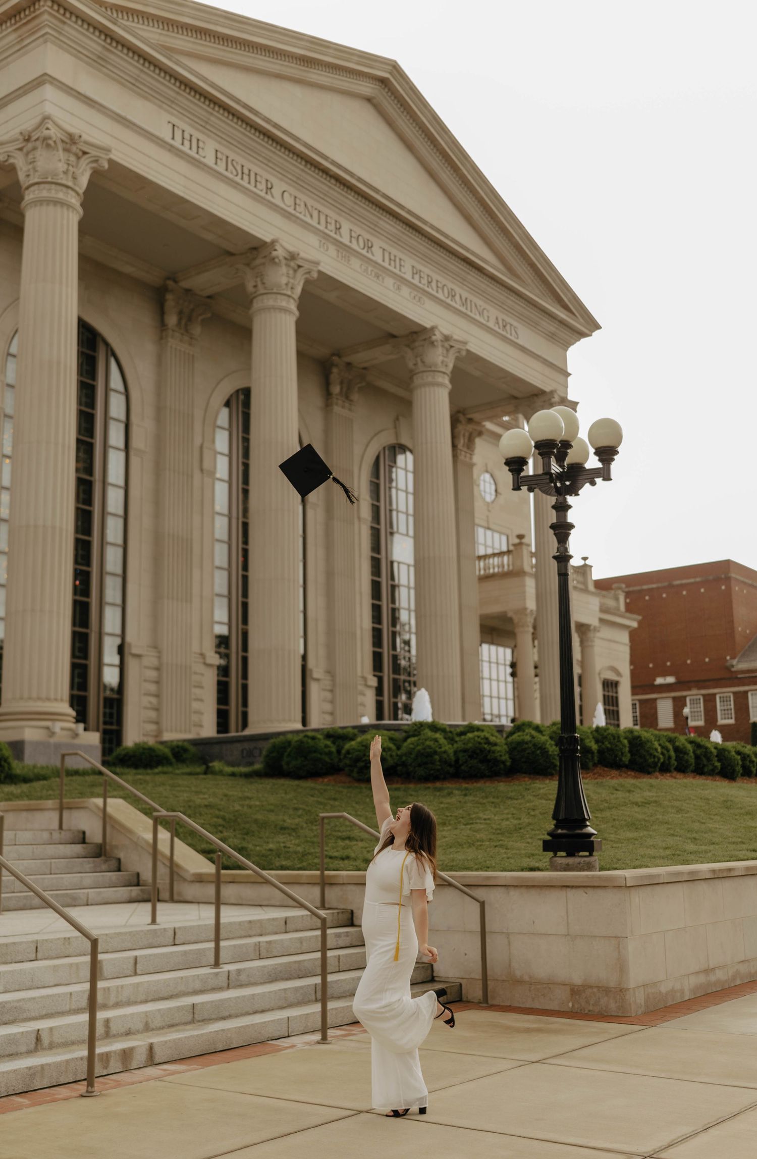 Graduation photo session in front of neoclassical building with grand columns.