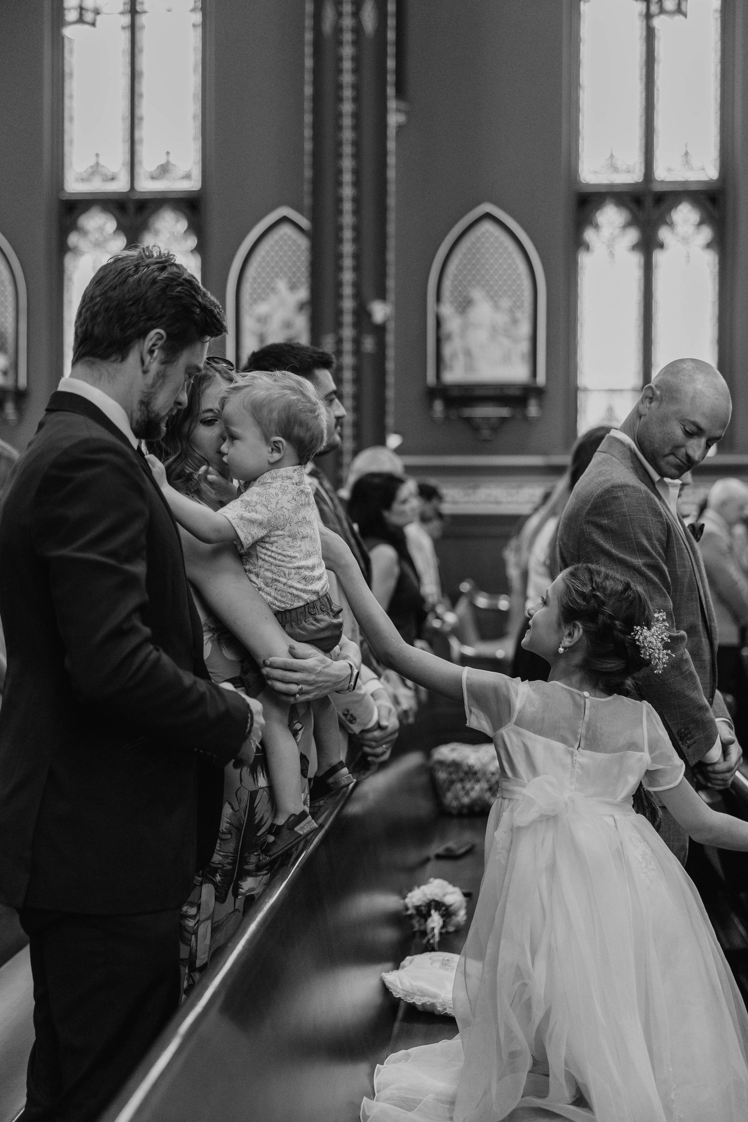 Dancing couples celebrate during an elegant indoor wedding reception with stained glass windows.