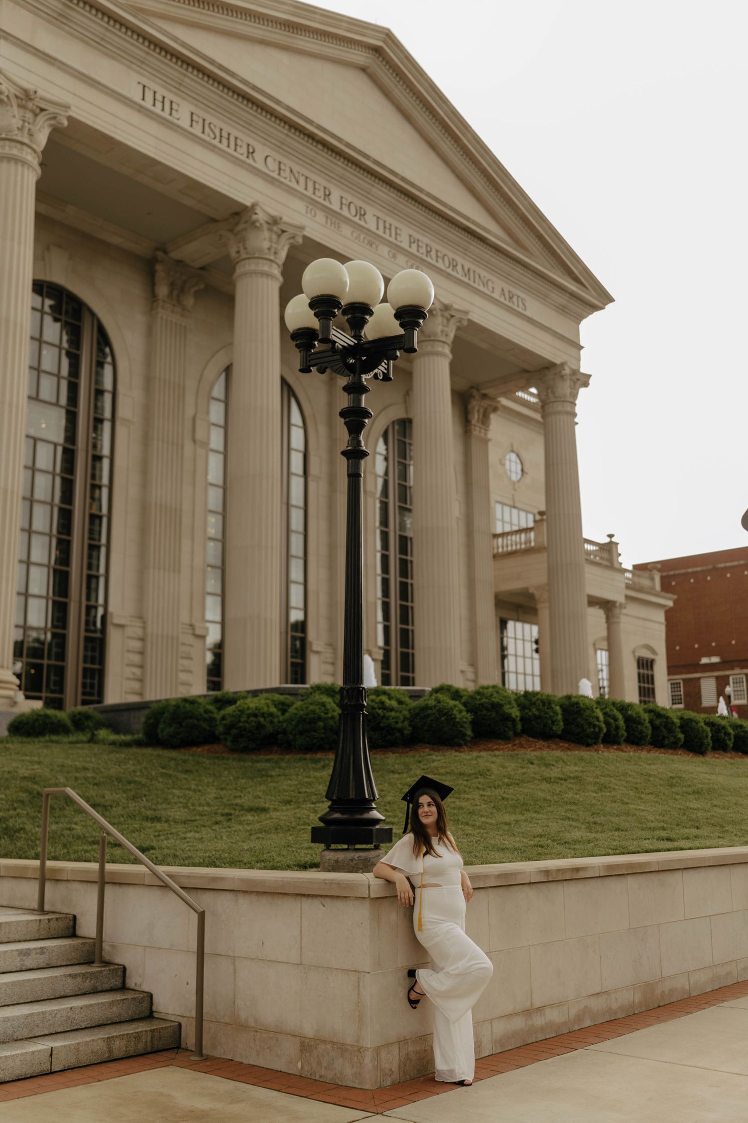 Graduate takes celebratory photos in front of stately building with columns.