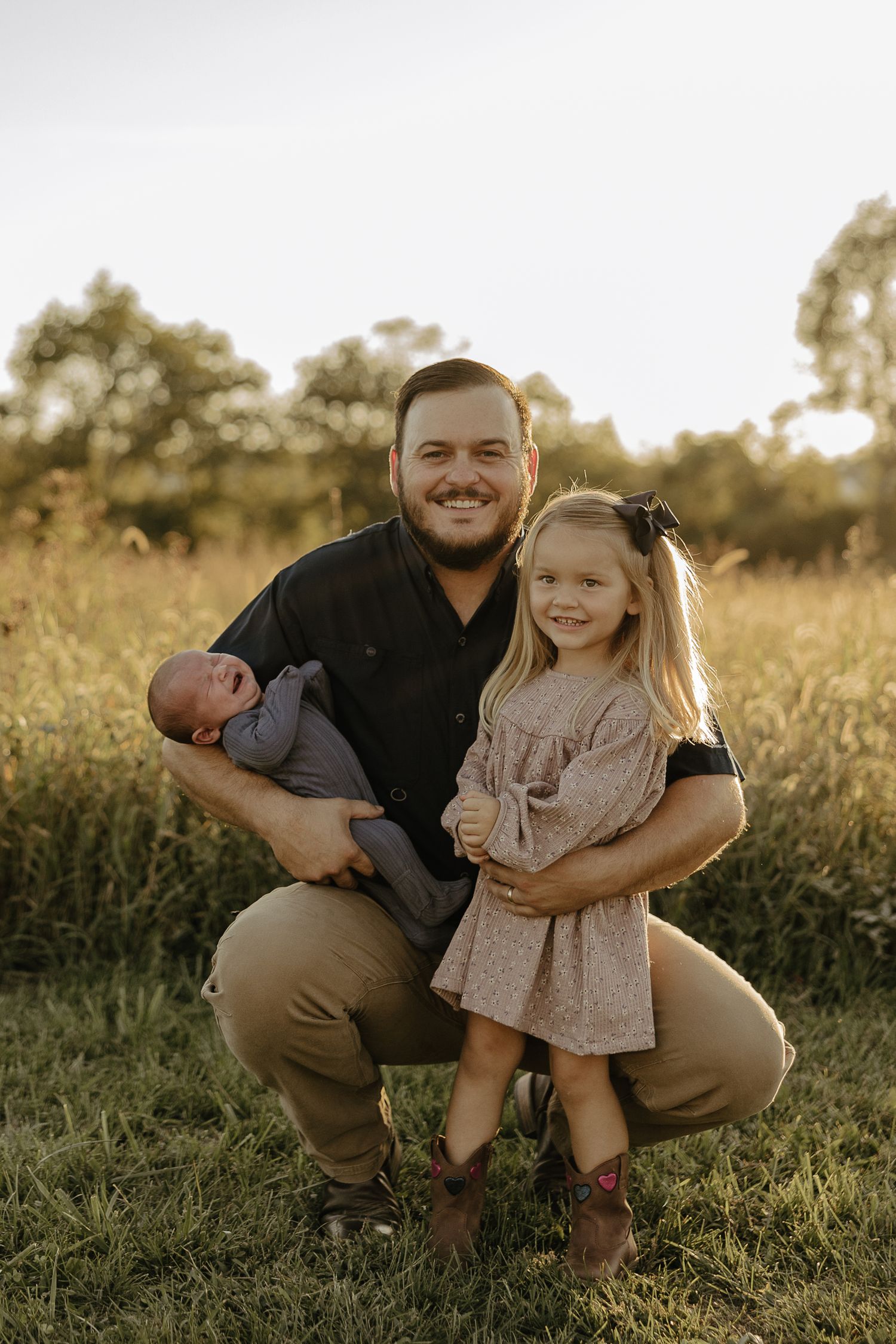 Father and daughter sharing joyful moments in a sunlit field.