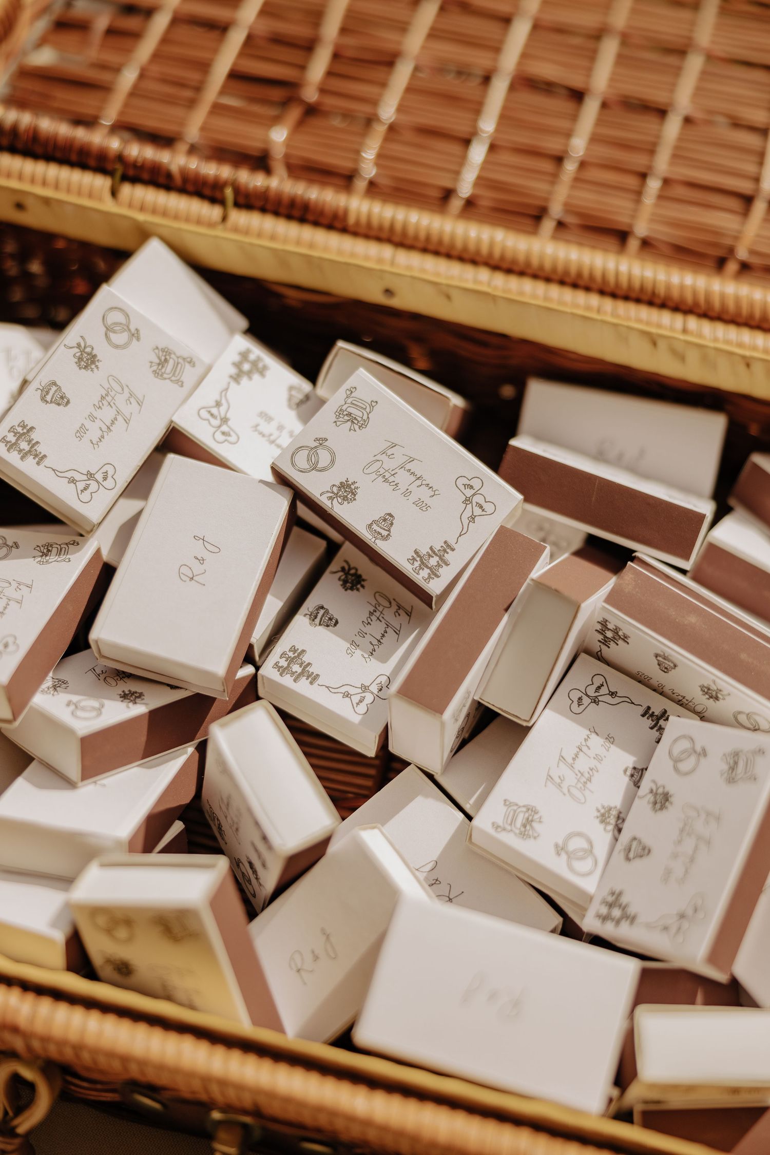 Multiple small white decorative gift boxes arranged in rows on a wooden surface.