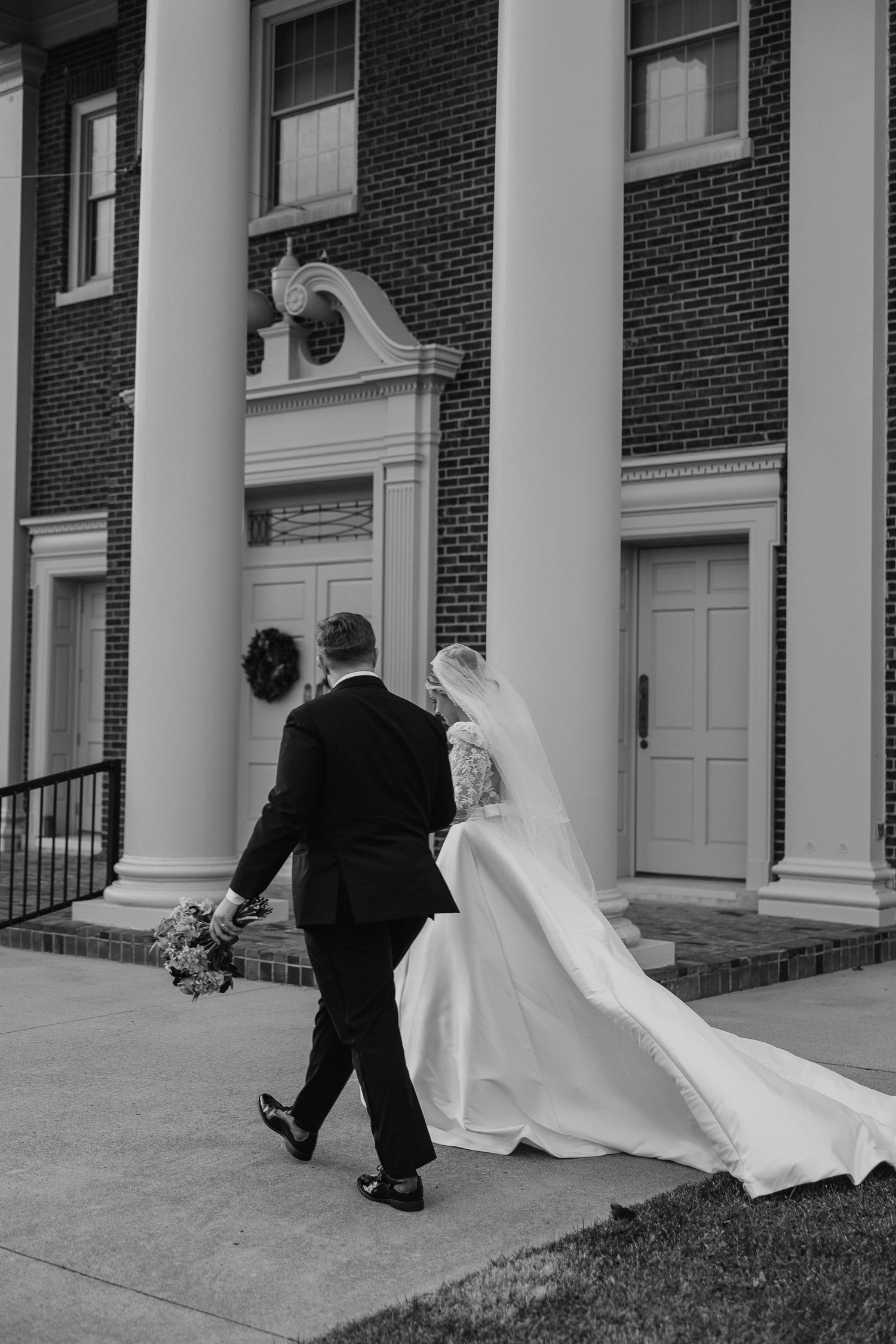 A series of black and white wedding photos showing a couple entering a brick building with white columns.