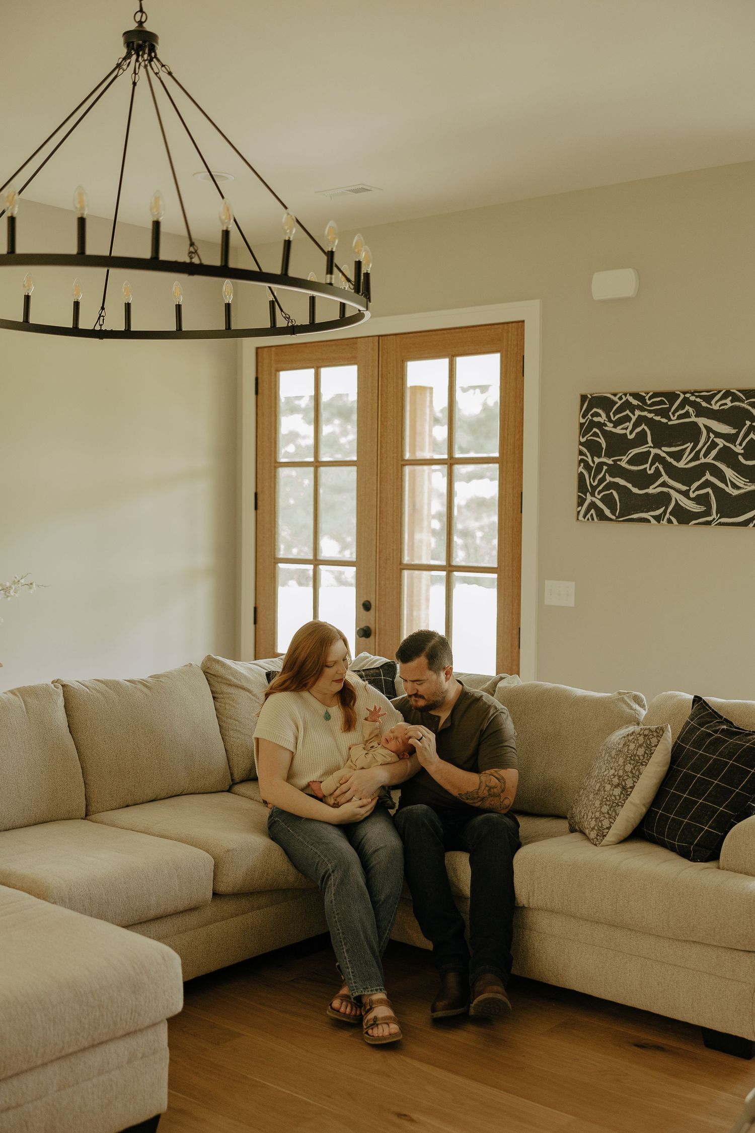 A cozy living room scene with a modern chandelier and sectional sofa.