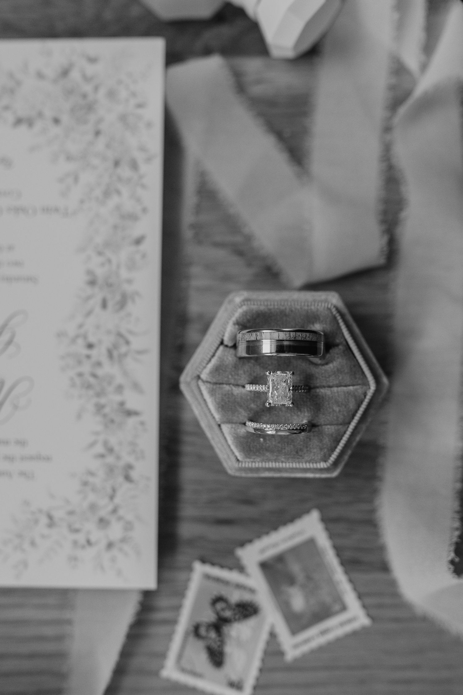 Black and white close-up photo of diamond engagement rings displayed on handwritten notes or papers.