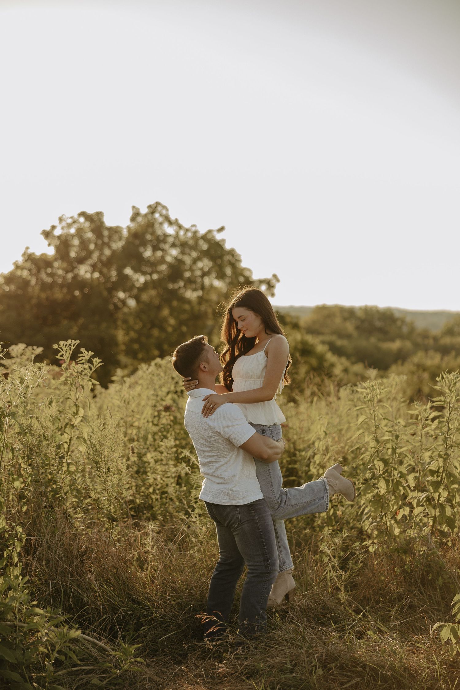 Romantic sunset photoshoot in a wildflower field with golden hour lighting.