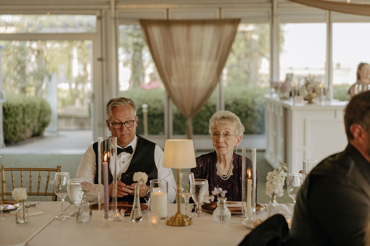 An elegant wedding reception venue with soft draping and table settings.