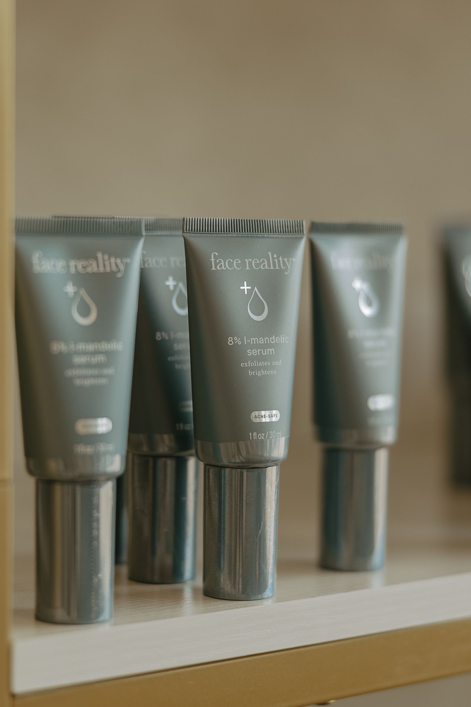 Close-up of Hue Reality branded gray cosmetic tubes displayed on white shelf.
