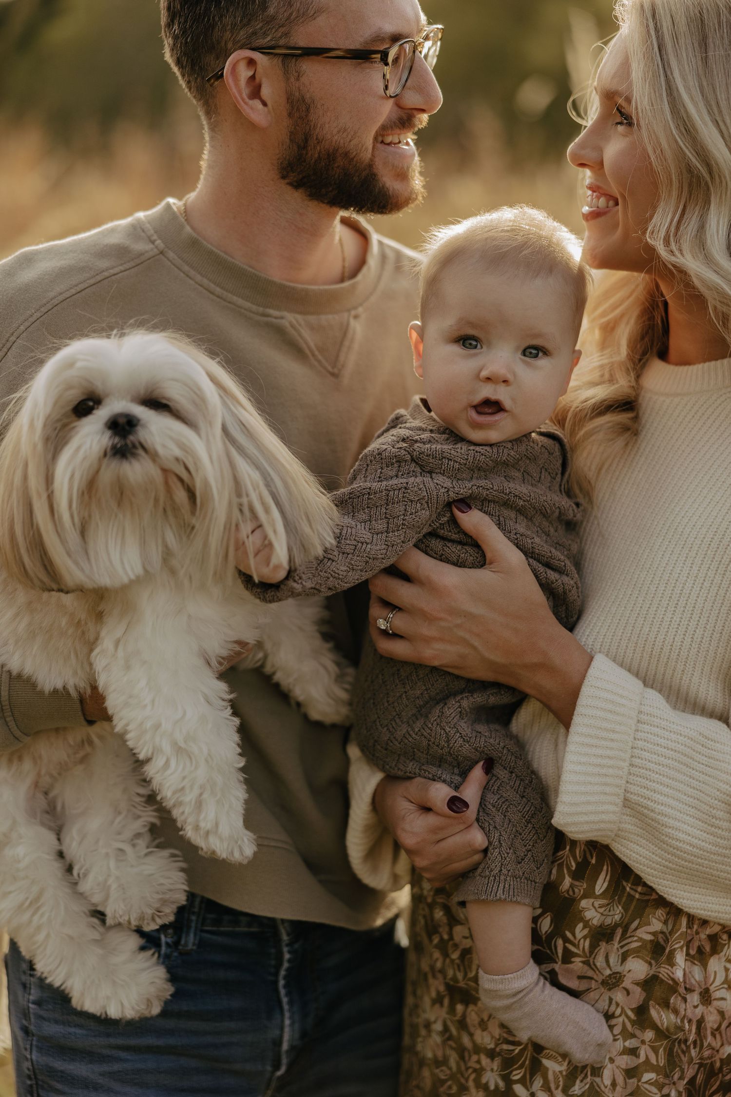Casual family photos with a white fluffy dog in autumn outdoor setting.