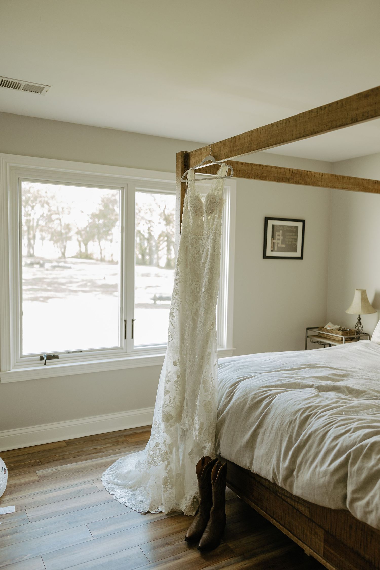Modern bedroom interior with wooden beams, large windows and white bedding.