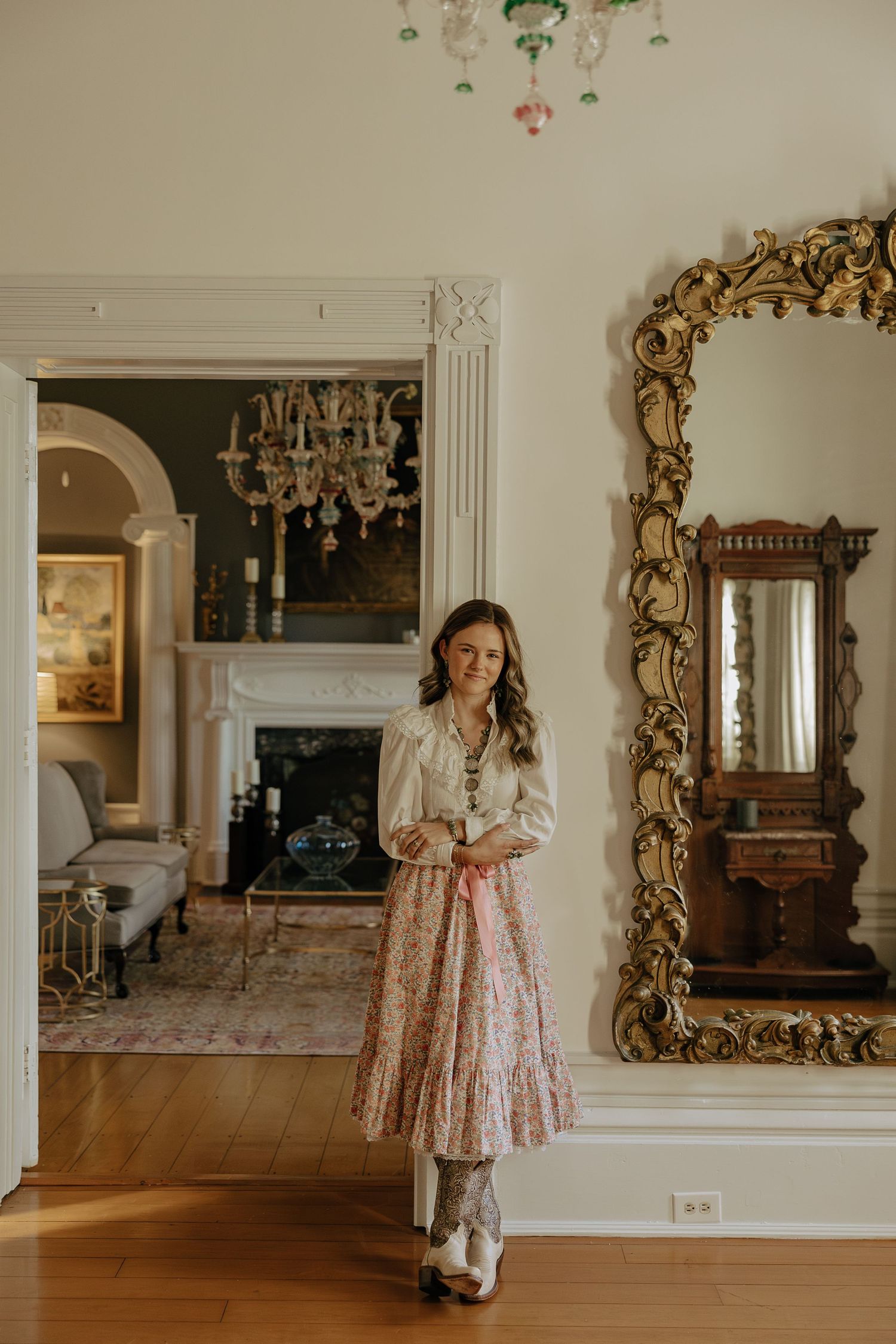A pink floral dress is shown in multiple reflections through ornate gold-framed mirrors in a bright interior.