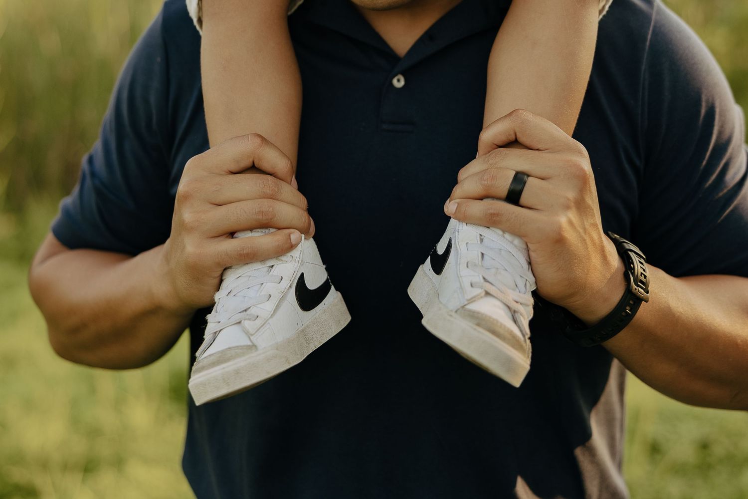 Close-up details of casual clothing and hands in an outdoor setting.
