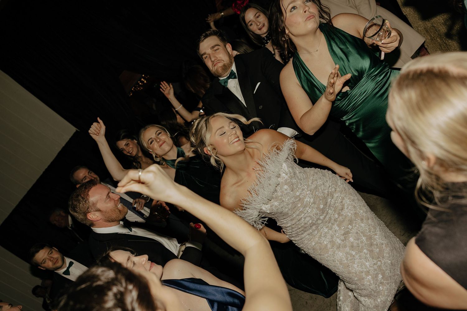 Crowd of people dancing and celebrating at a lively party or nightclub event.