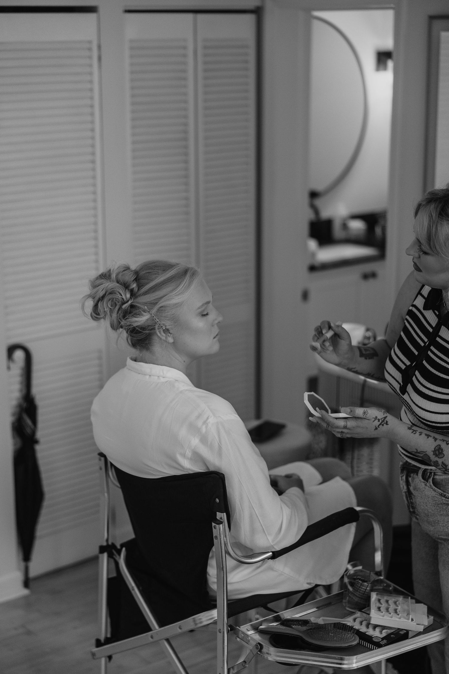 Black and white photo of wedding preparation in a salon setting.
