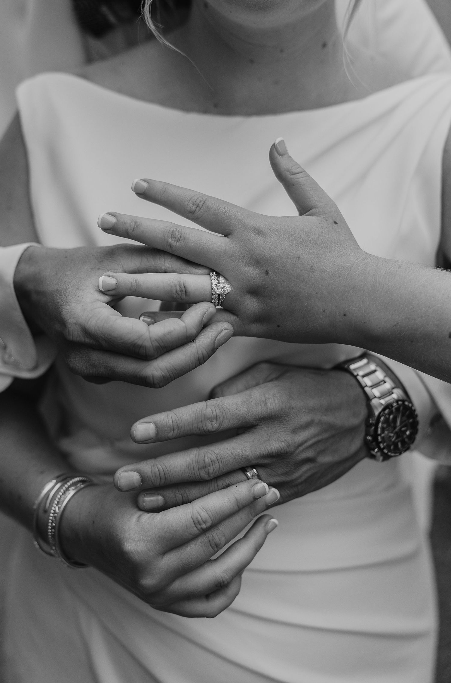 A sequence of black and white photos showing hands with engagement and wedding rings from different angles.