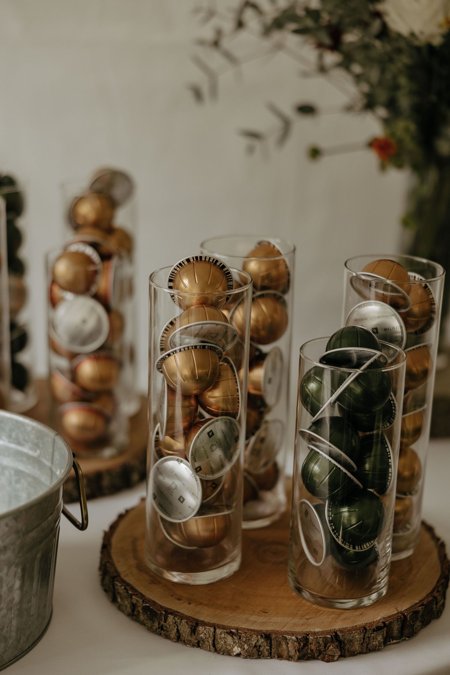 Glass jars with monogram initials displayed on rustic wood slices as wedding decor.