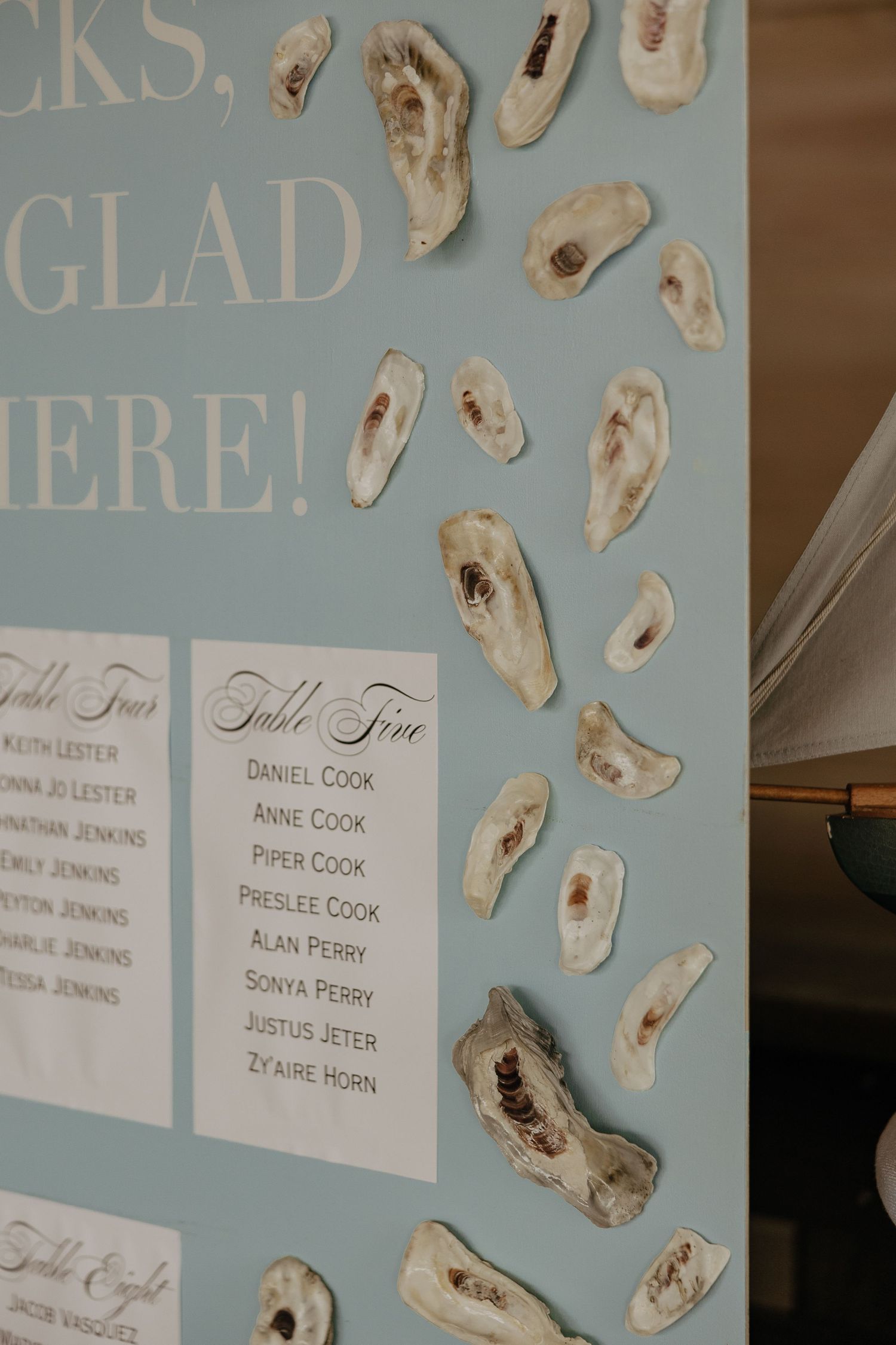 A blue wall display featuring oyster shells and name cards in an elegant arrangement.
