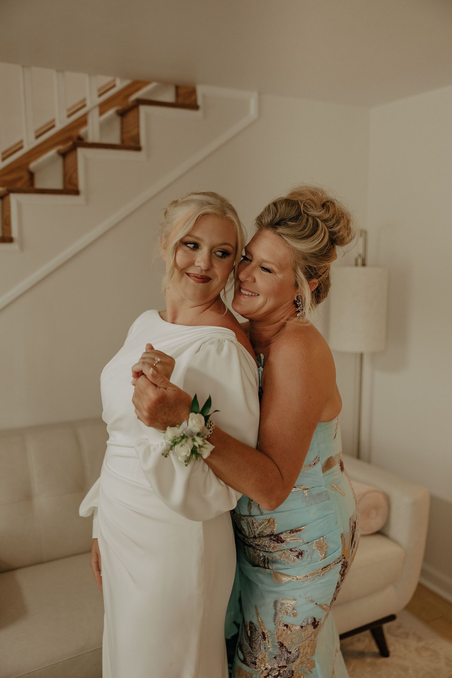Two people share an emotional embrace while wearing formal attire.
