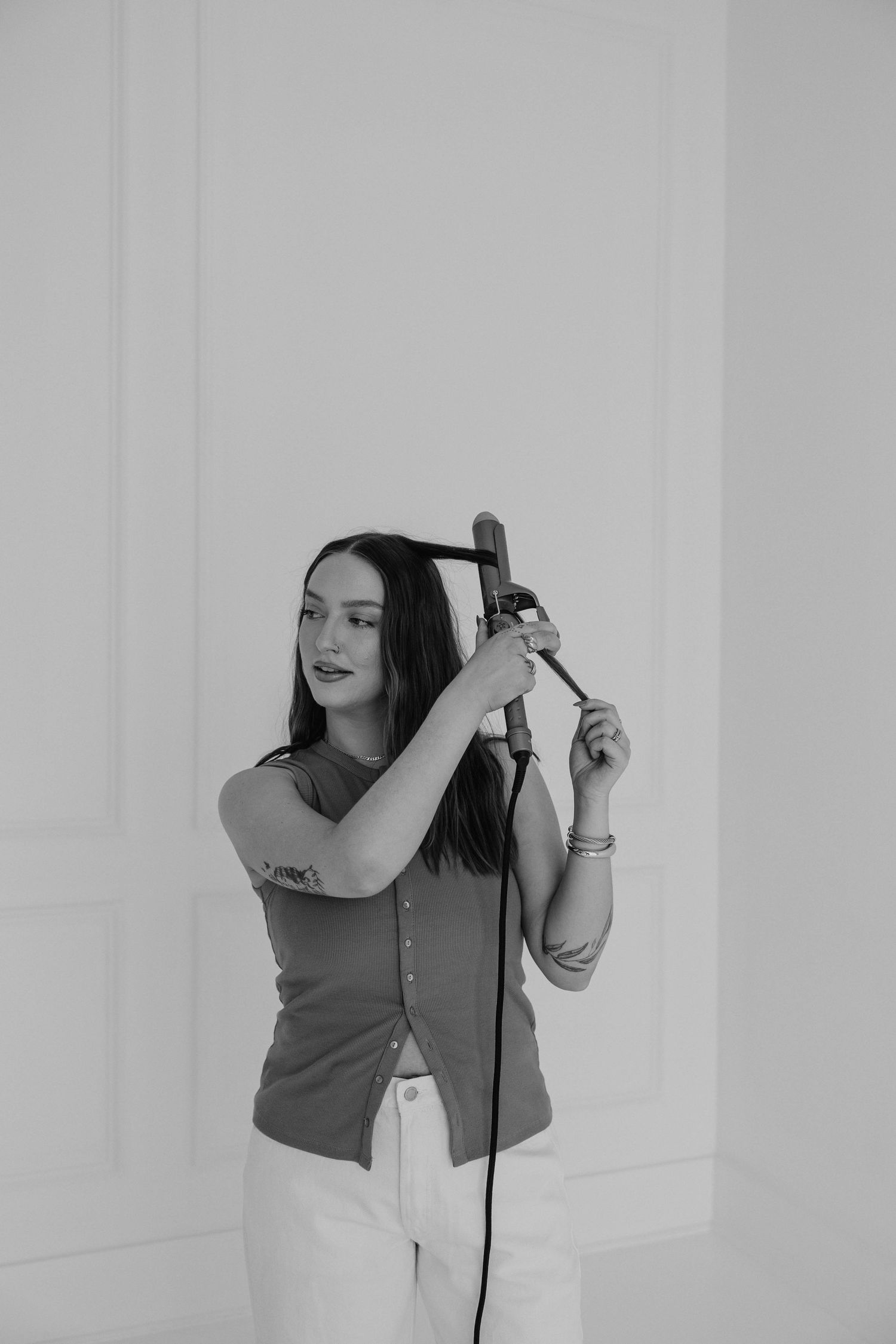 Black and white image showing hair styling technique with professional tool.