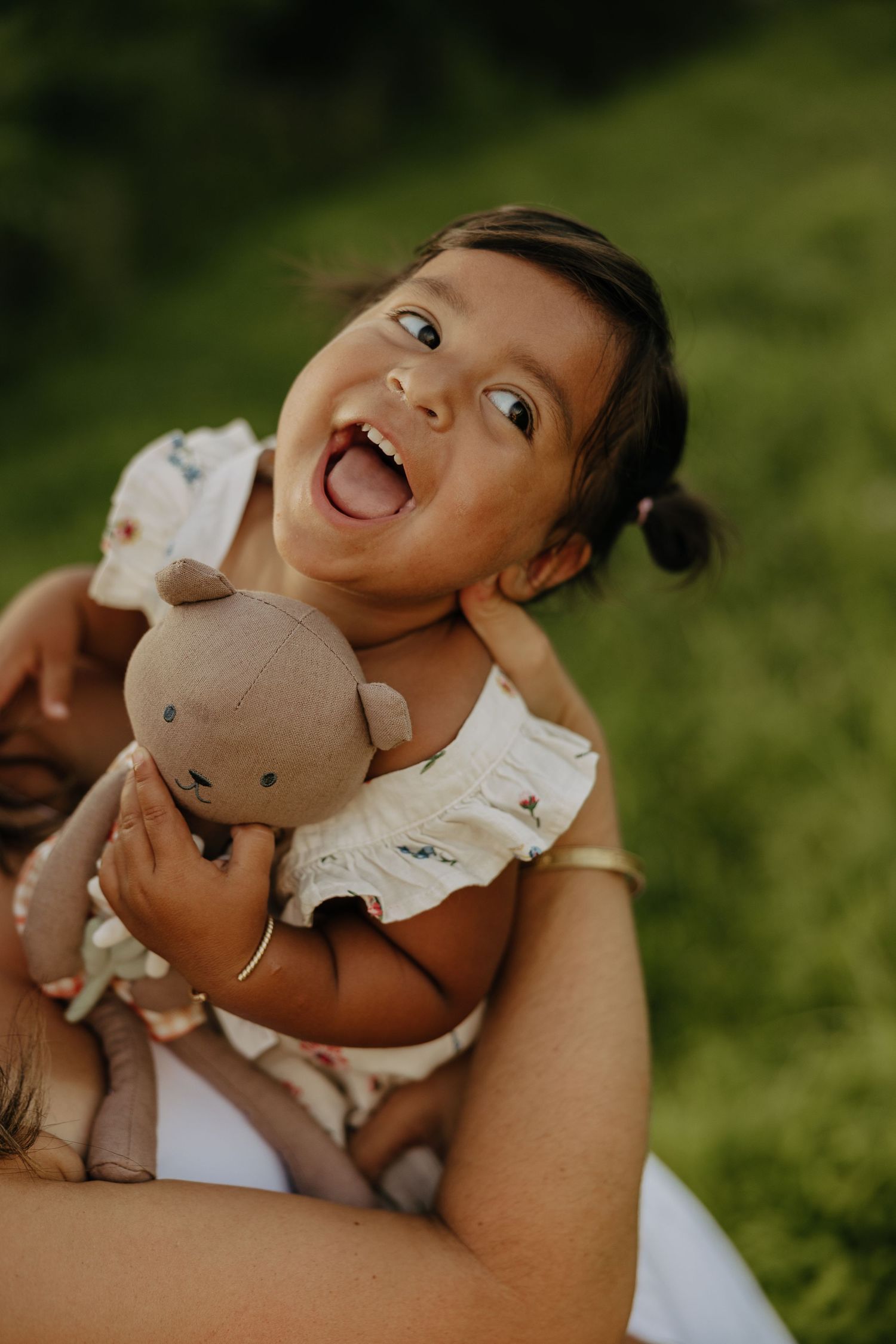Playful moments with a stuffed toy in natural outdoor lighting.