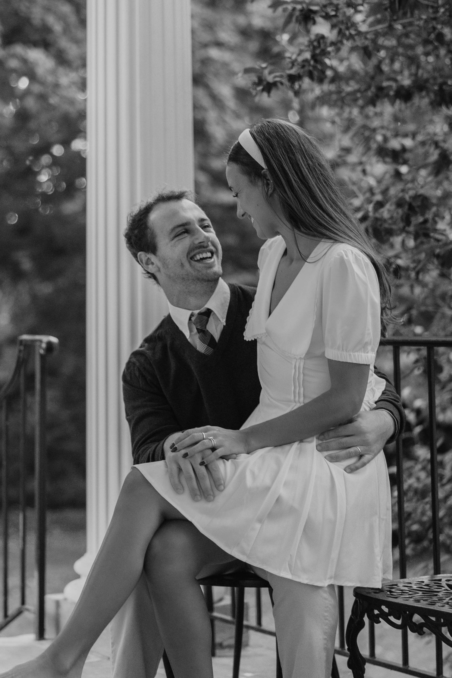 Joyful couple sharing laughs while sitting together on outdoor steps.