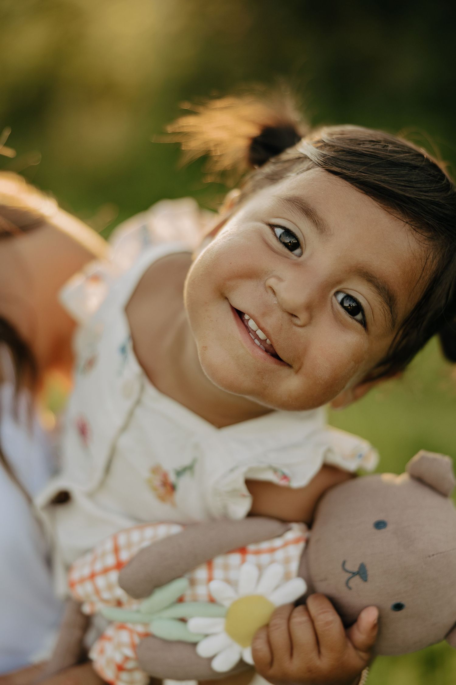 Close-up portrait showing a gentle smile against a soft blurred background.