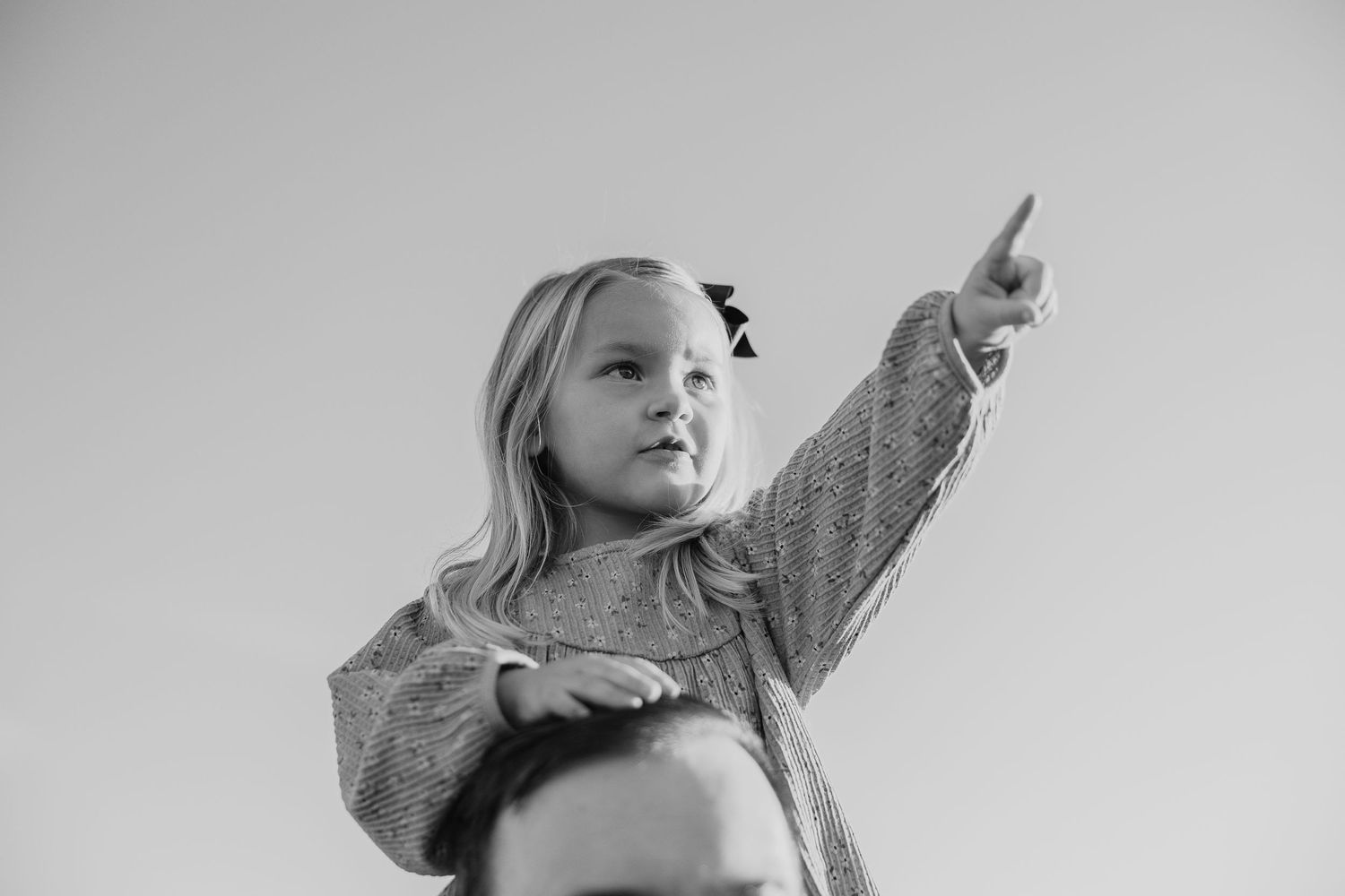 Person gestures expressively against a bright, minimalist background.