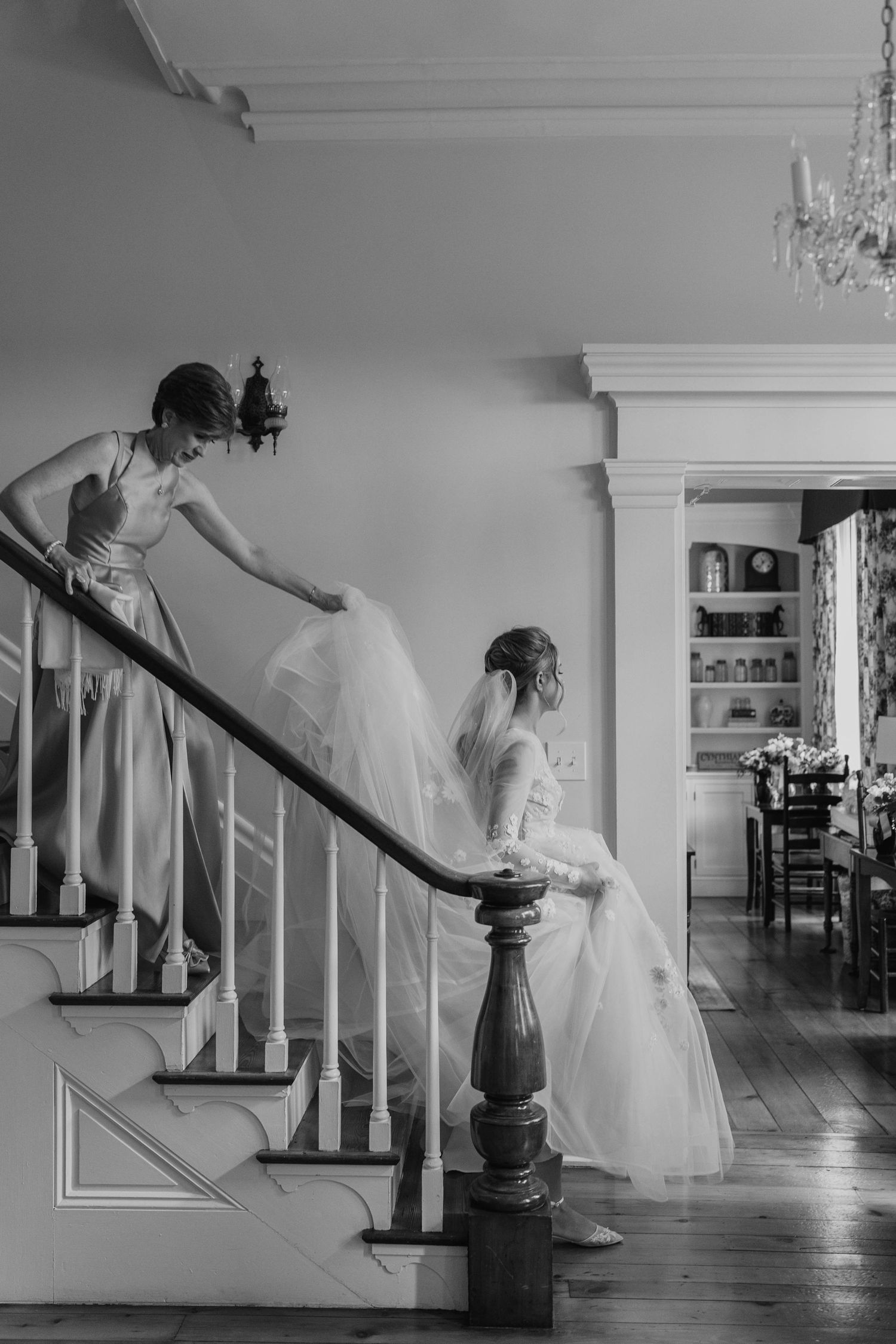 Artistic black and white series showing movement on a classic staircase with white railings.