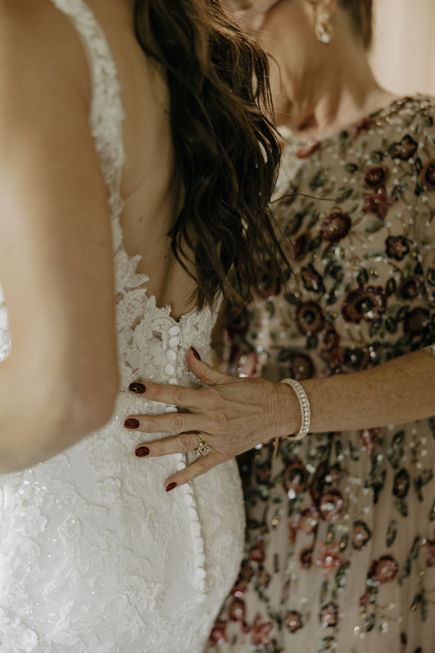 Close-up details of an elegant lace wedding dress with floral patterns.