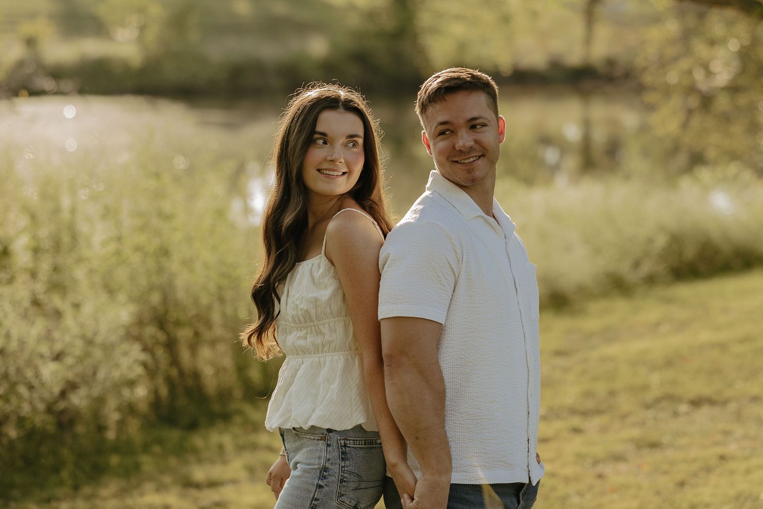 Couple shares tender moments in sun-drenched summer field.