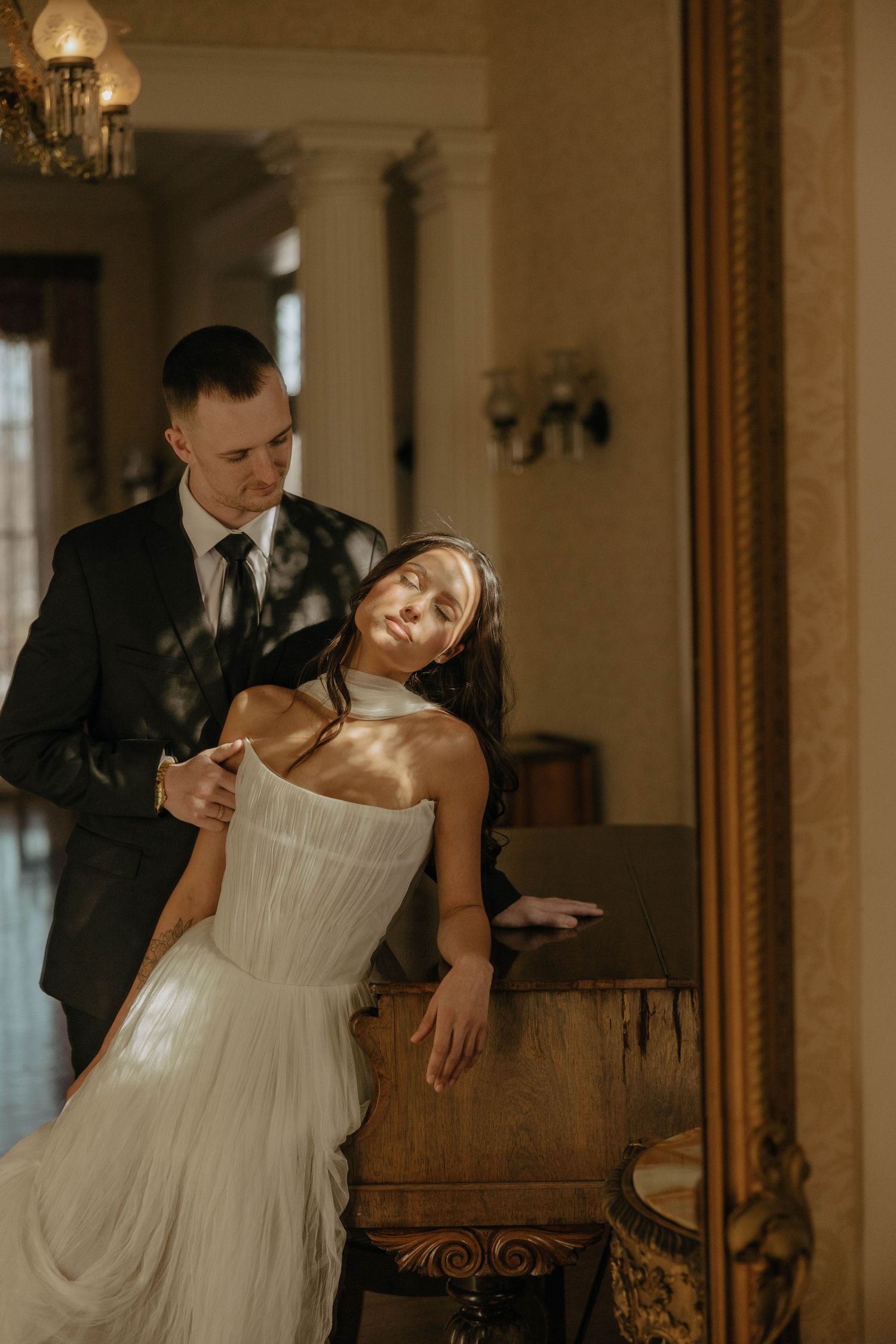 Artistic wedding dance poses captured in warm tones against ornate vintage mirrors.