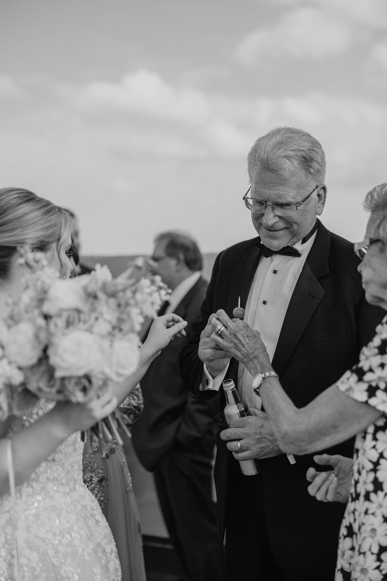 Black and white candid moment at outdoor wedding celebration.