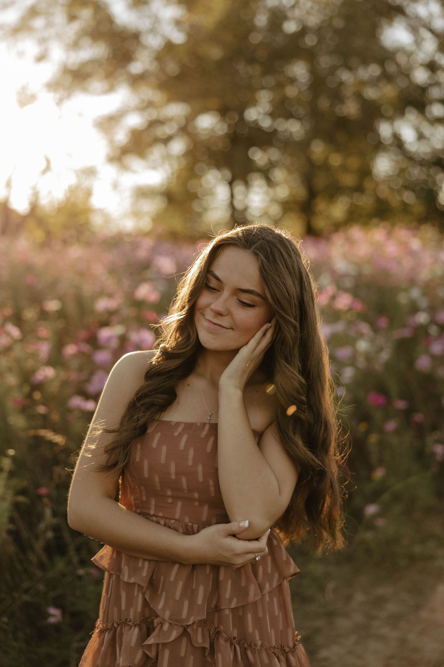 A candid moment captured in a field of pink flowers at sunset.
