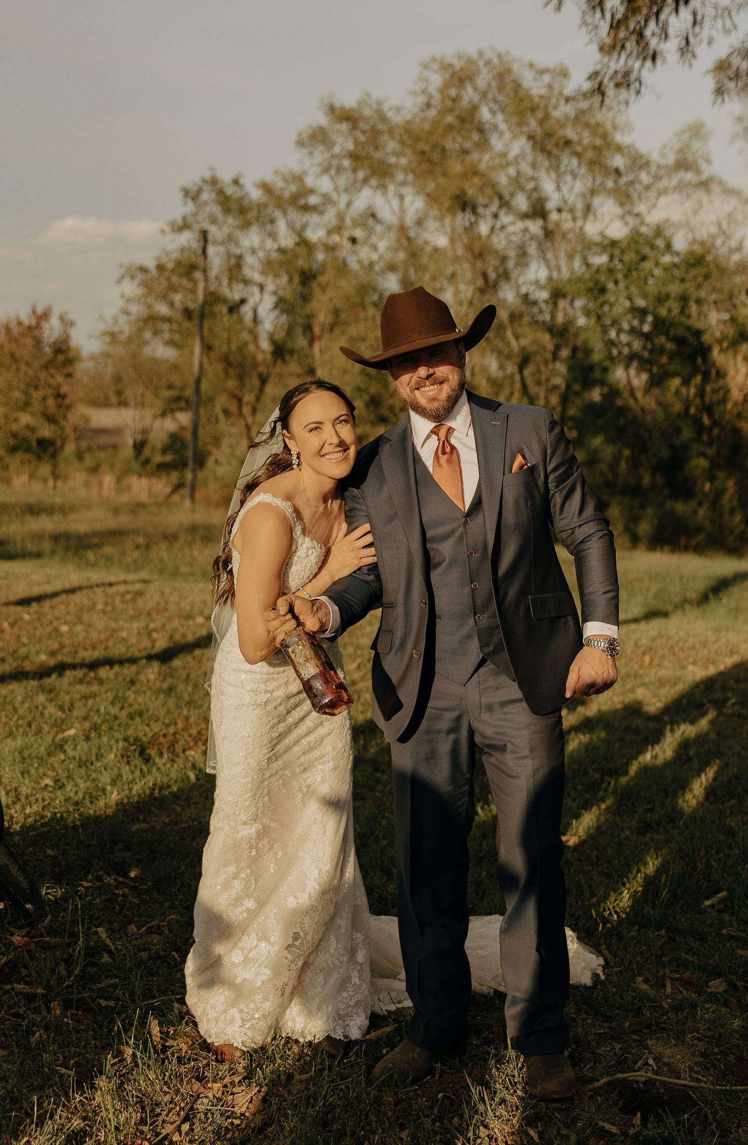 Couple sharing joyful moments during sunset wedding photos in an outdoor autumn setting.