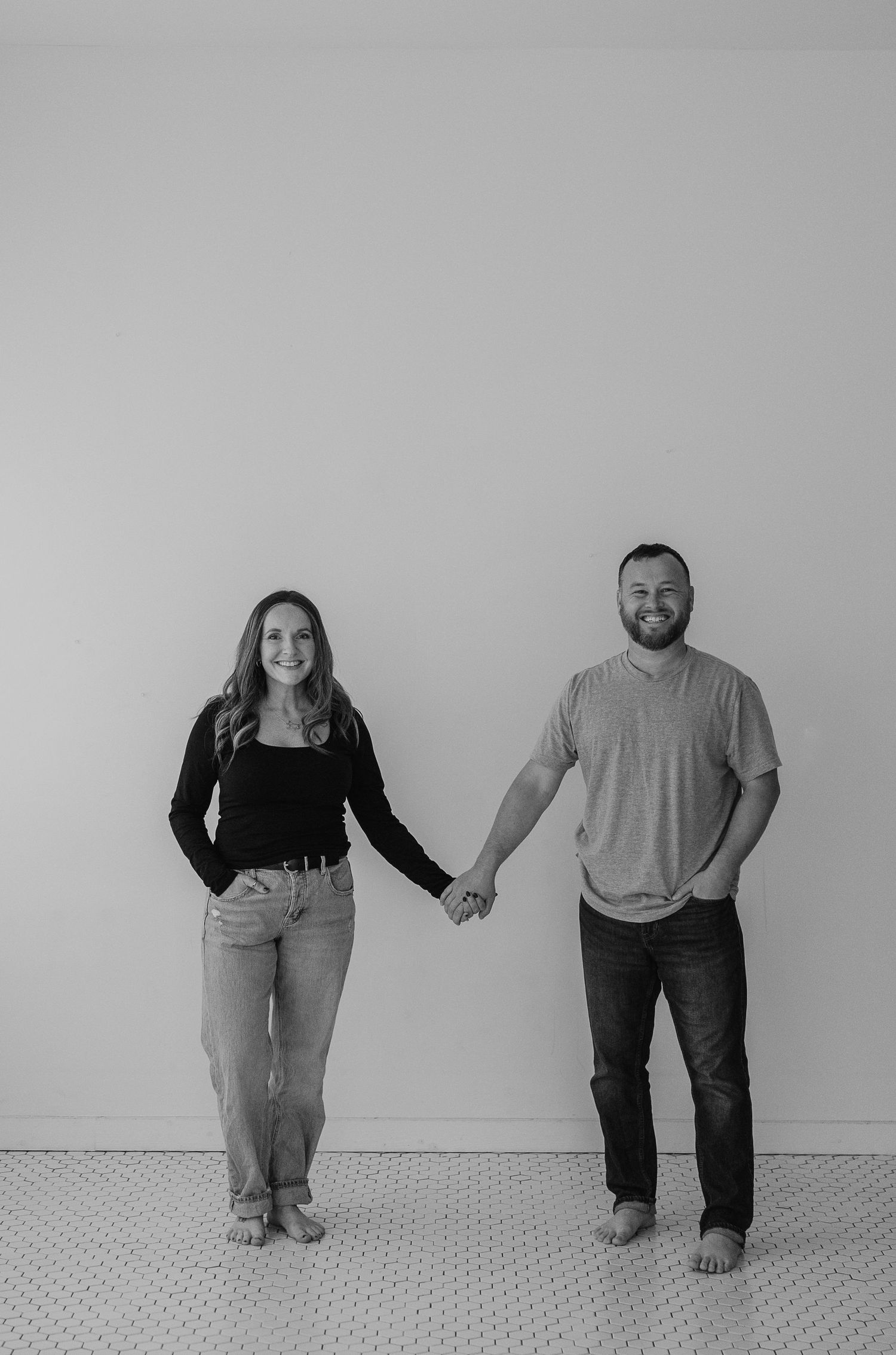 A black and white photo sequence shows two people holding hands and playfully leaning away from each other against a wall.