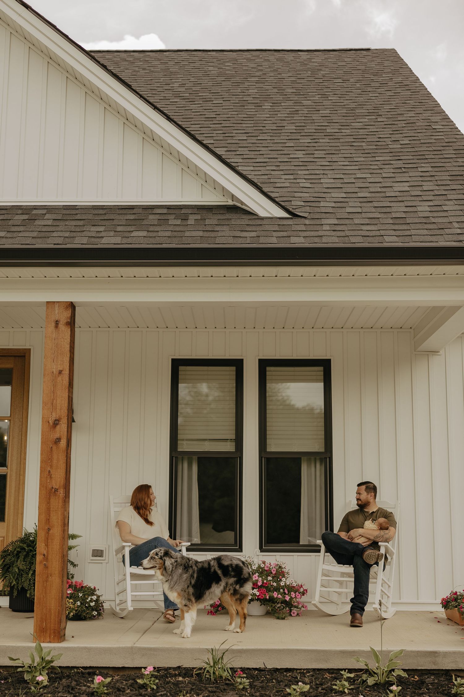 A couple shares a romantic dance moment on their white farmhouse porch.