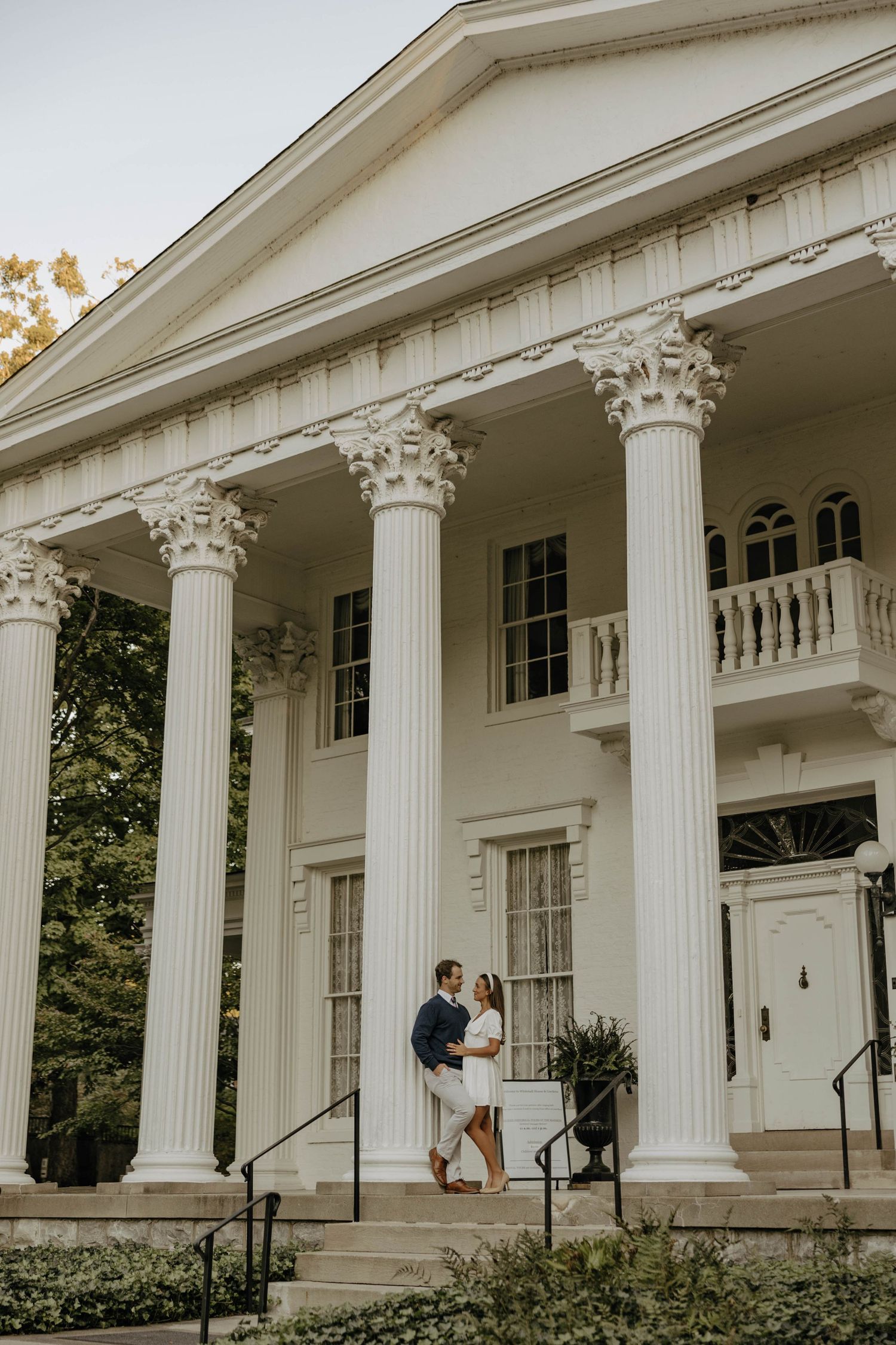 Stately white colonial mansion with ornate columns and architectural details.