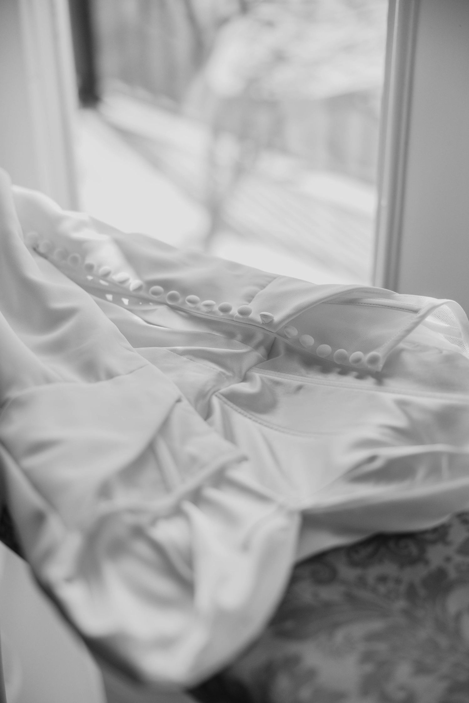 A series of blurry black and white photographs showing wrinkled white fabric or bedding in close-up detail.