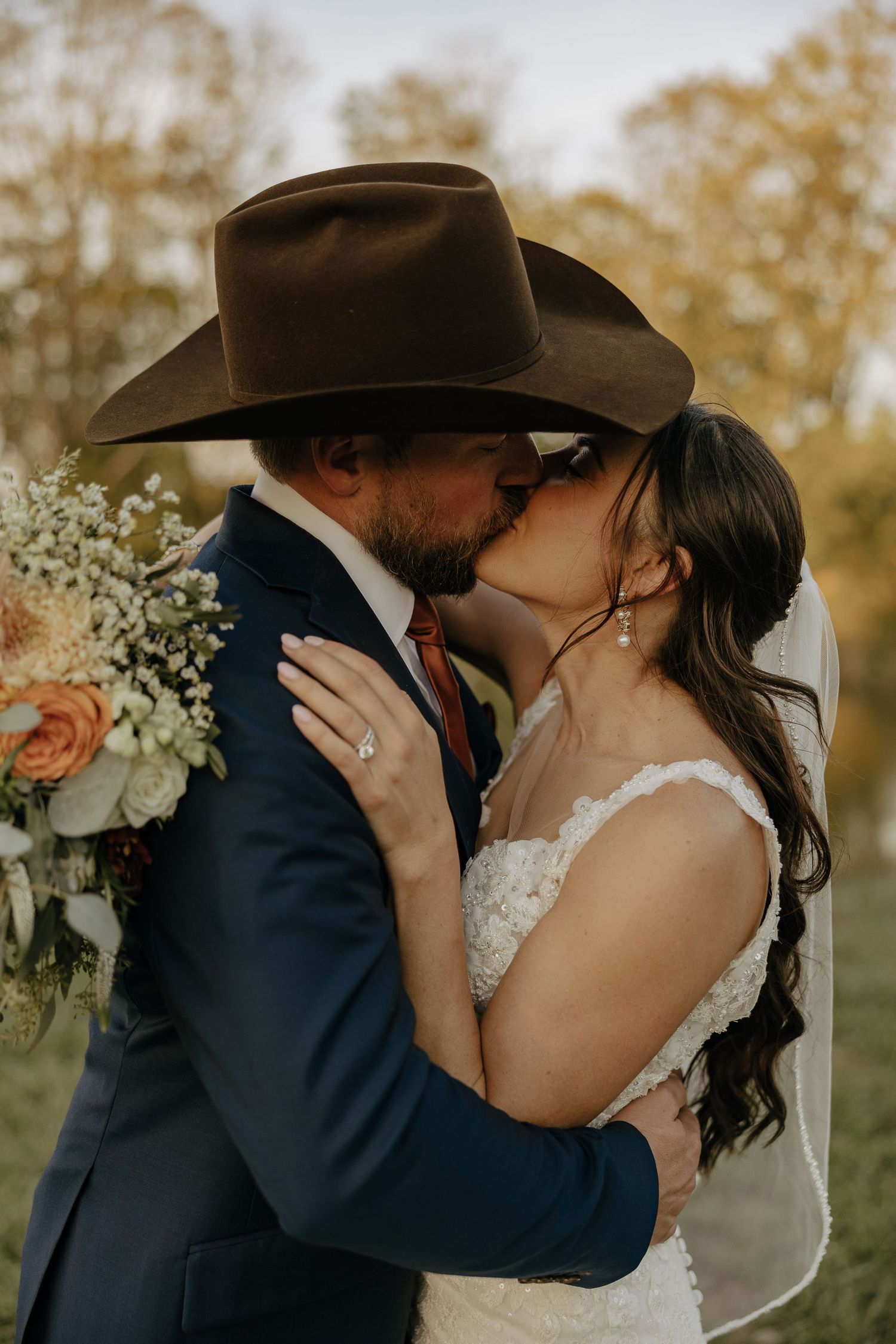 A romantic series of wedding photos showing a couple in cowboy hats sharing intimate moments against an autumn backdrop.
