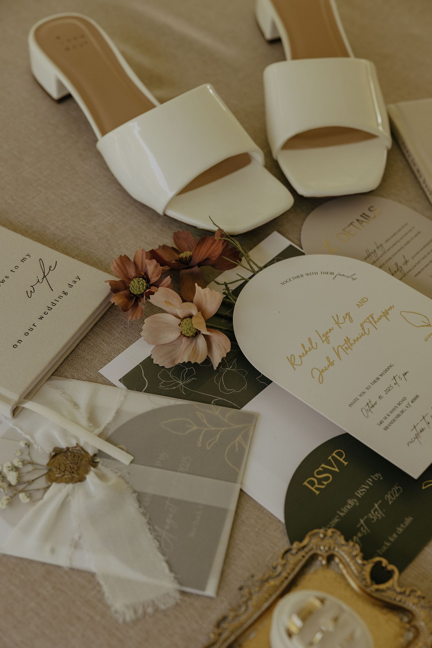 Wedding stationery and floral details arranged artistically with delicate pink flowers and elegant calligraphy.