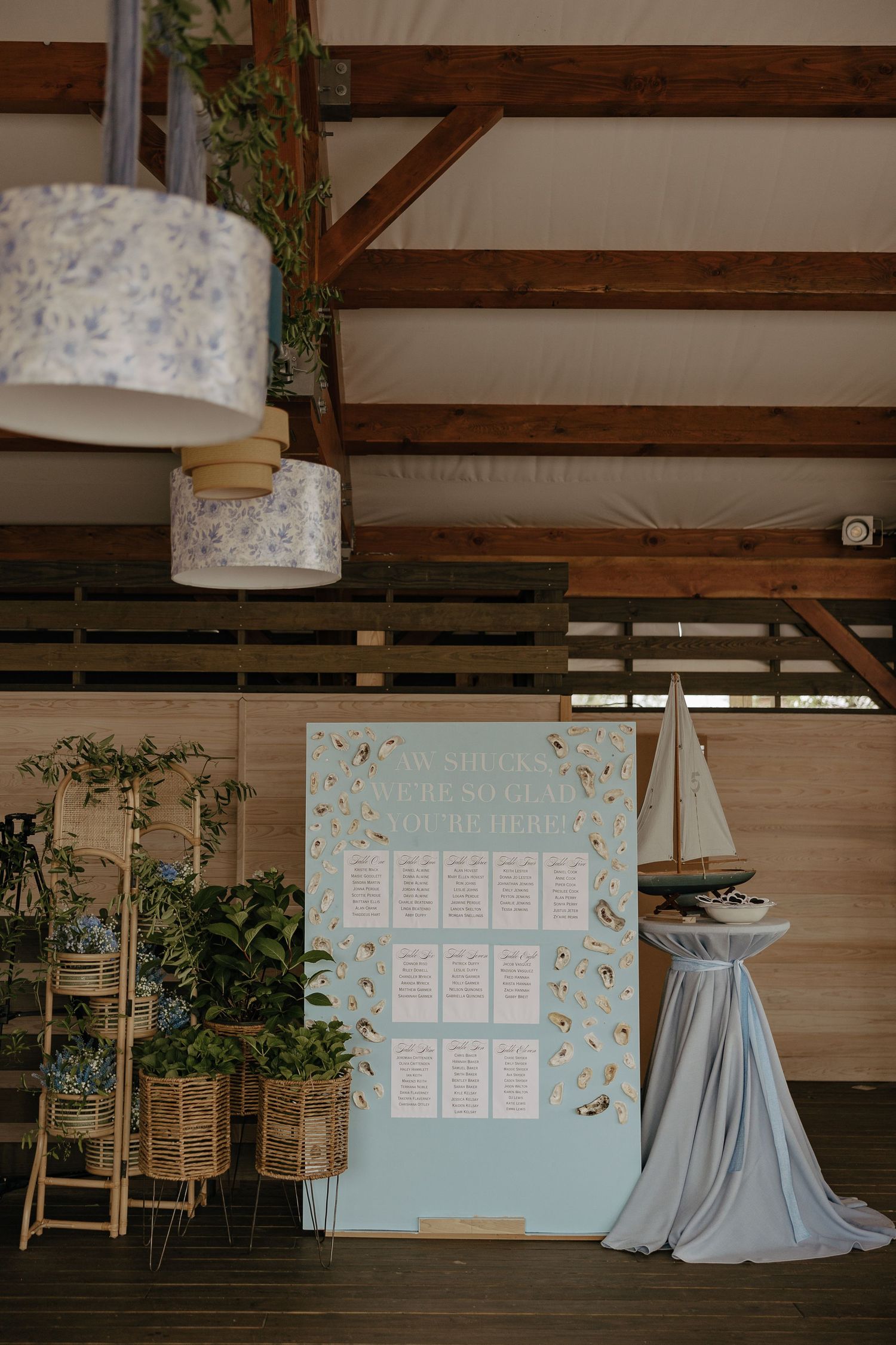 Wedding seating chart display with nautical decor and soft blue accents.