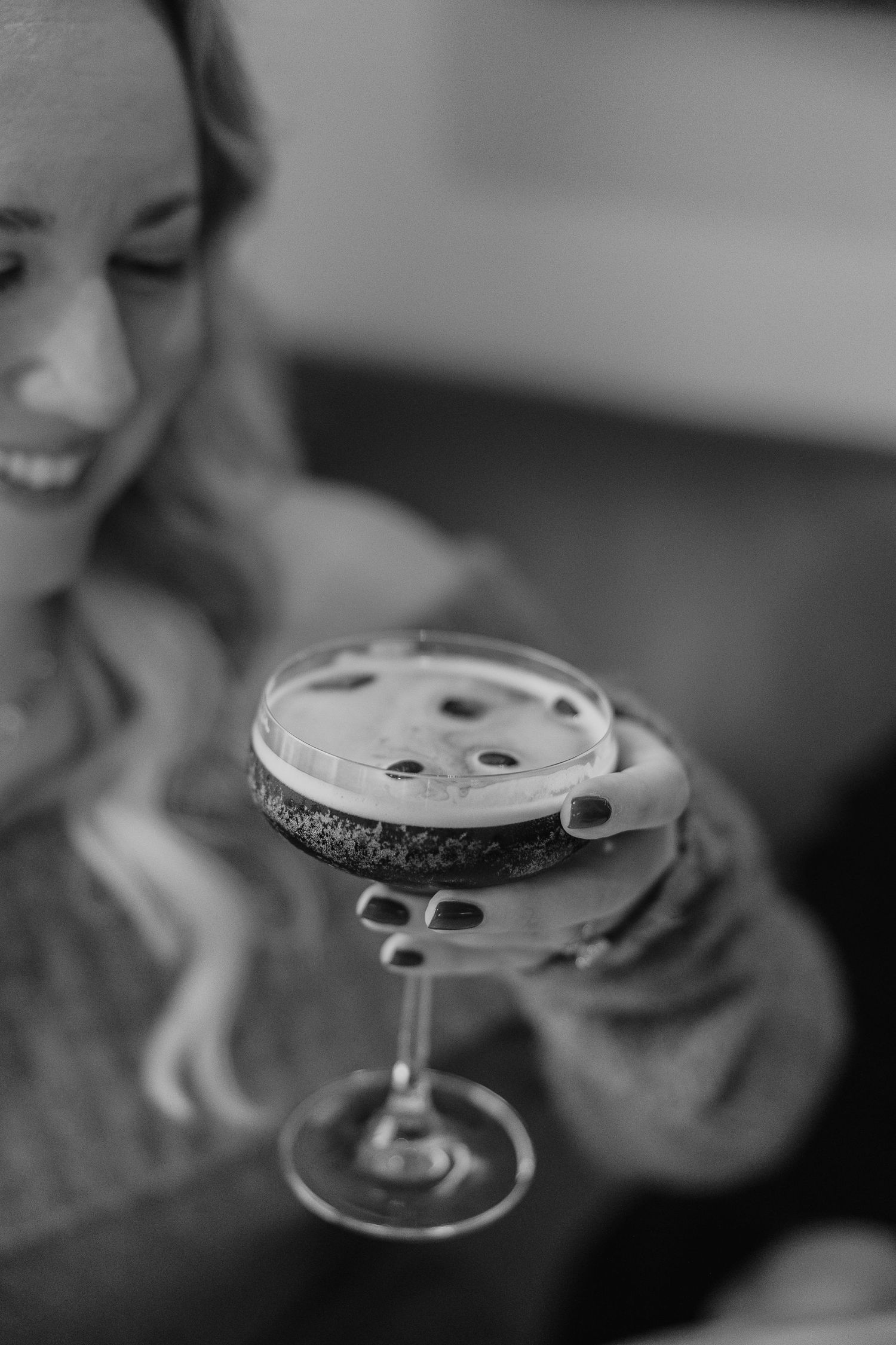 Artistic black and white photo of cocktail glasses with decorative garnishes.