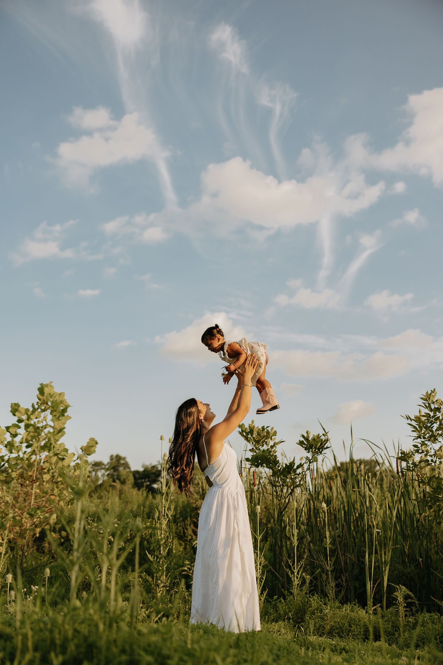 Candid moments of joy captured in a summer field under blue skies.
