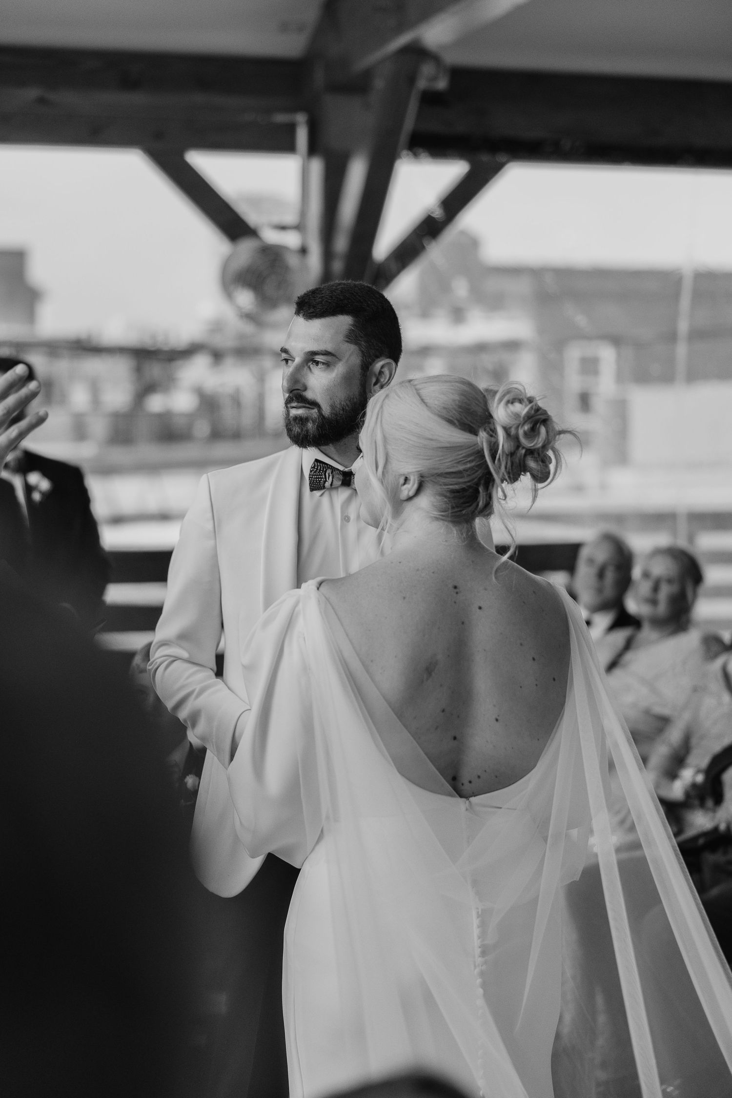 Black and white candid moments during wedding reception toasts.