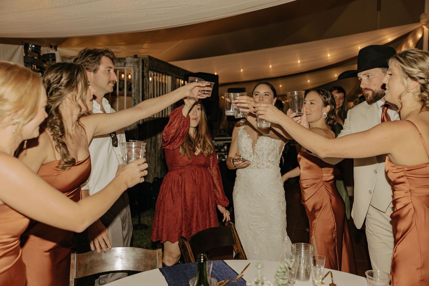 Wedding guests form a dance circle during a lively reception celebration.