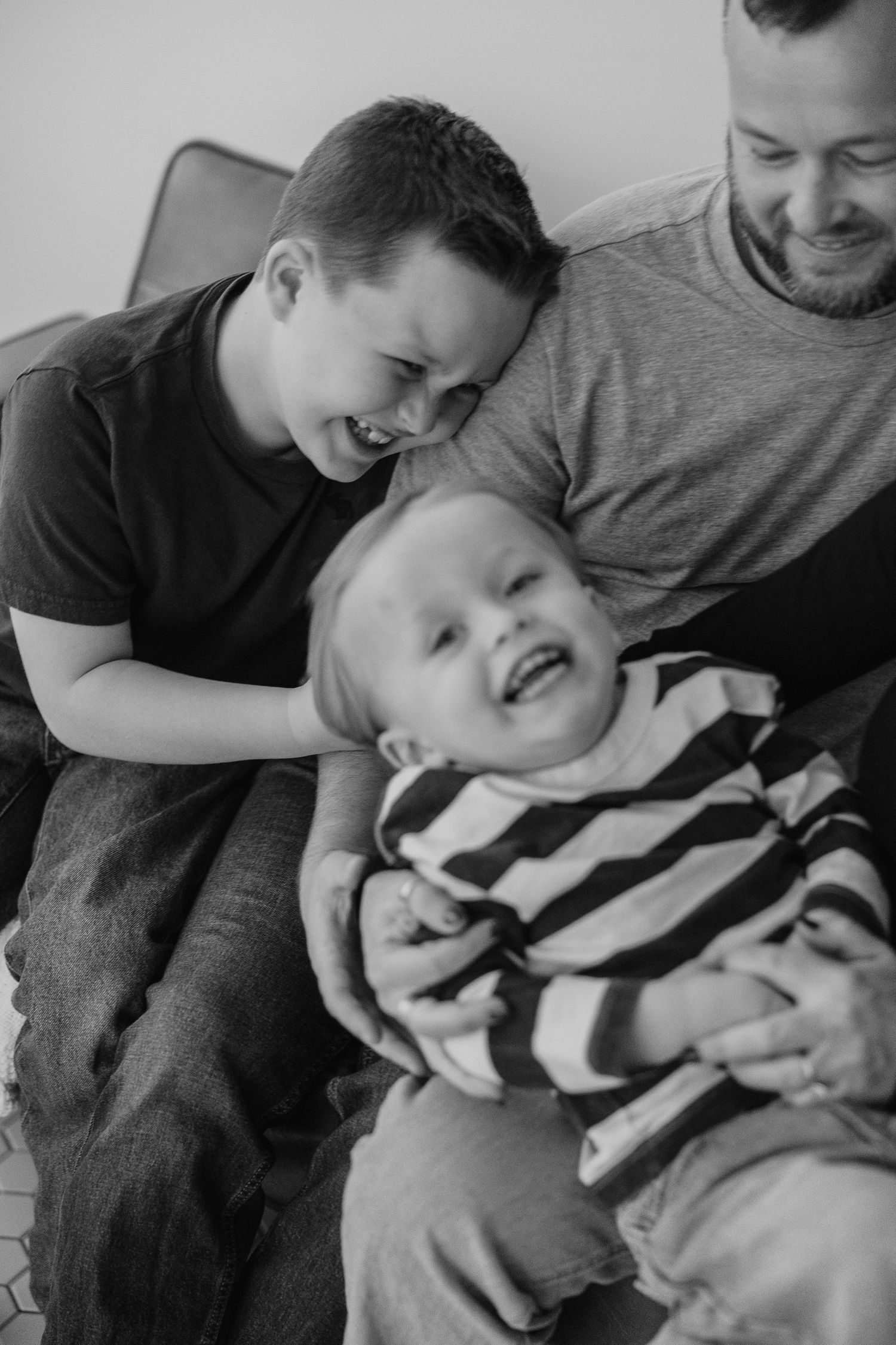 Intimate black and white portrait capturing genuine laughter and joy between family members.