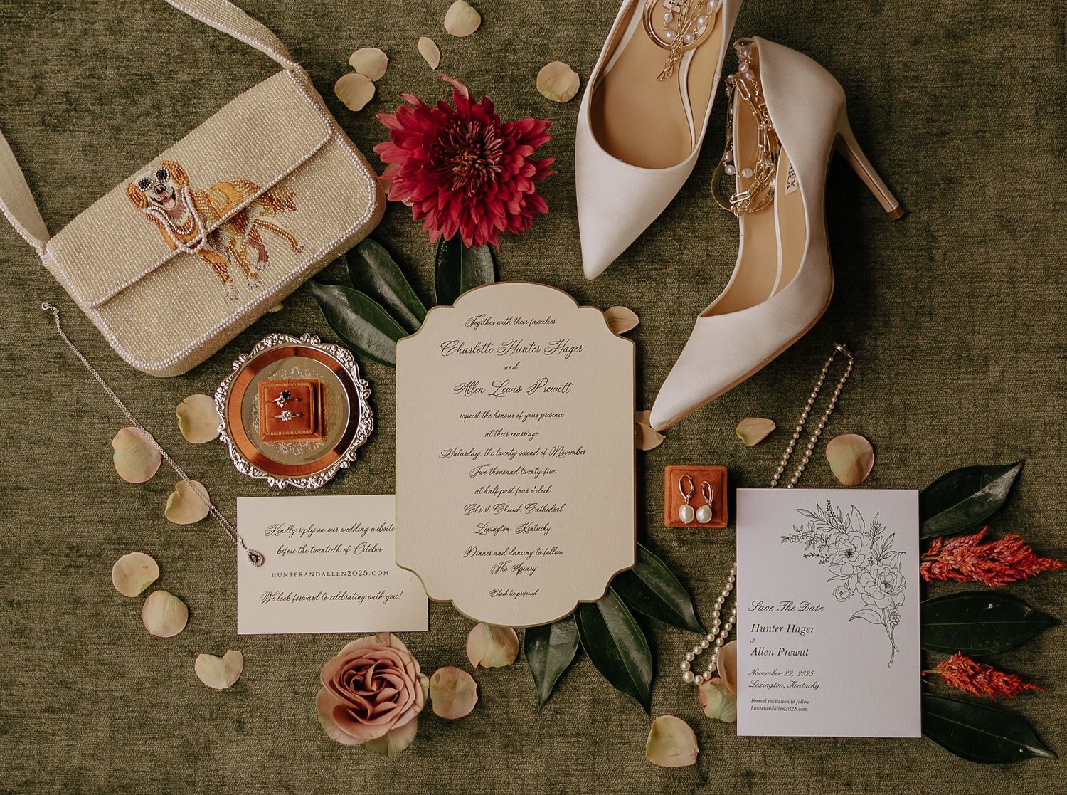 Elegant wedding invitation suite with rose gold shoes, red florals and vintage-inspired decor on dark textured background.