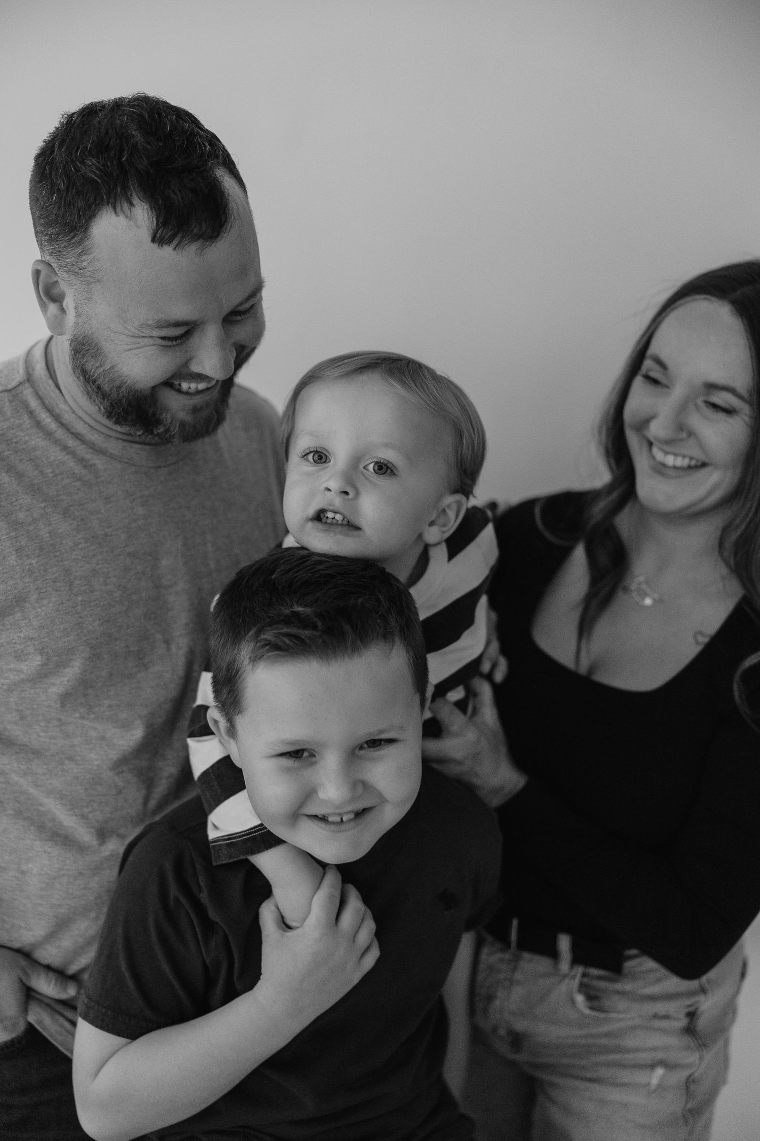 An intimate black and white family moment showing joyful expressions and natural interaction.