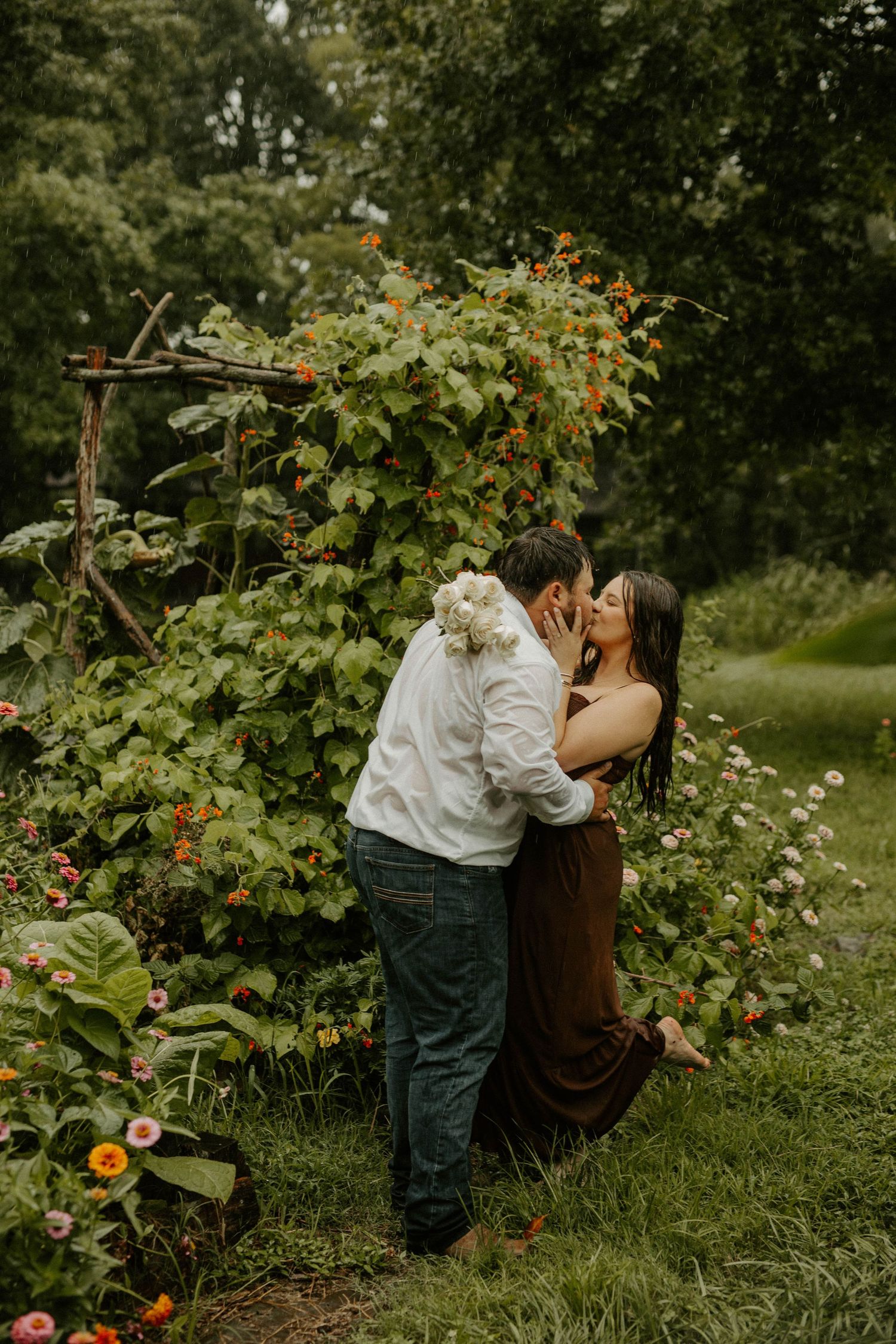 Mother and child share tender moments in a lush garden with blooming flowers.