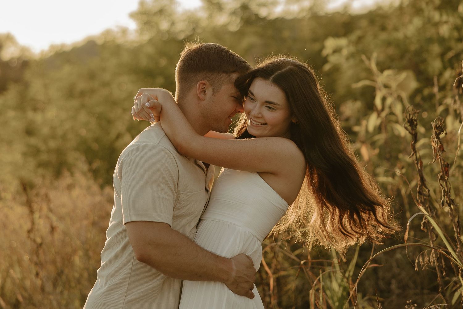 Golden hour couple's photoshoot in a natural outdoor setting with warm lighting.